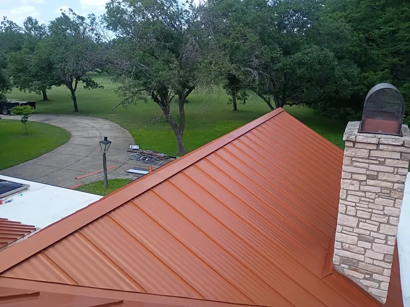 Copper-tone standing seam metal roof installed by RISE Roofing
